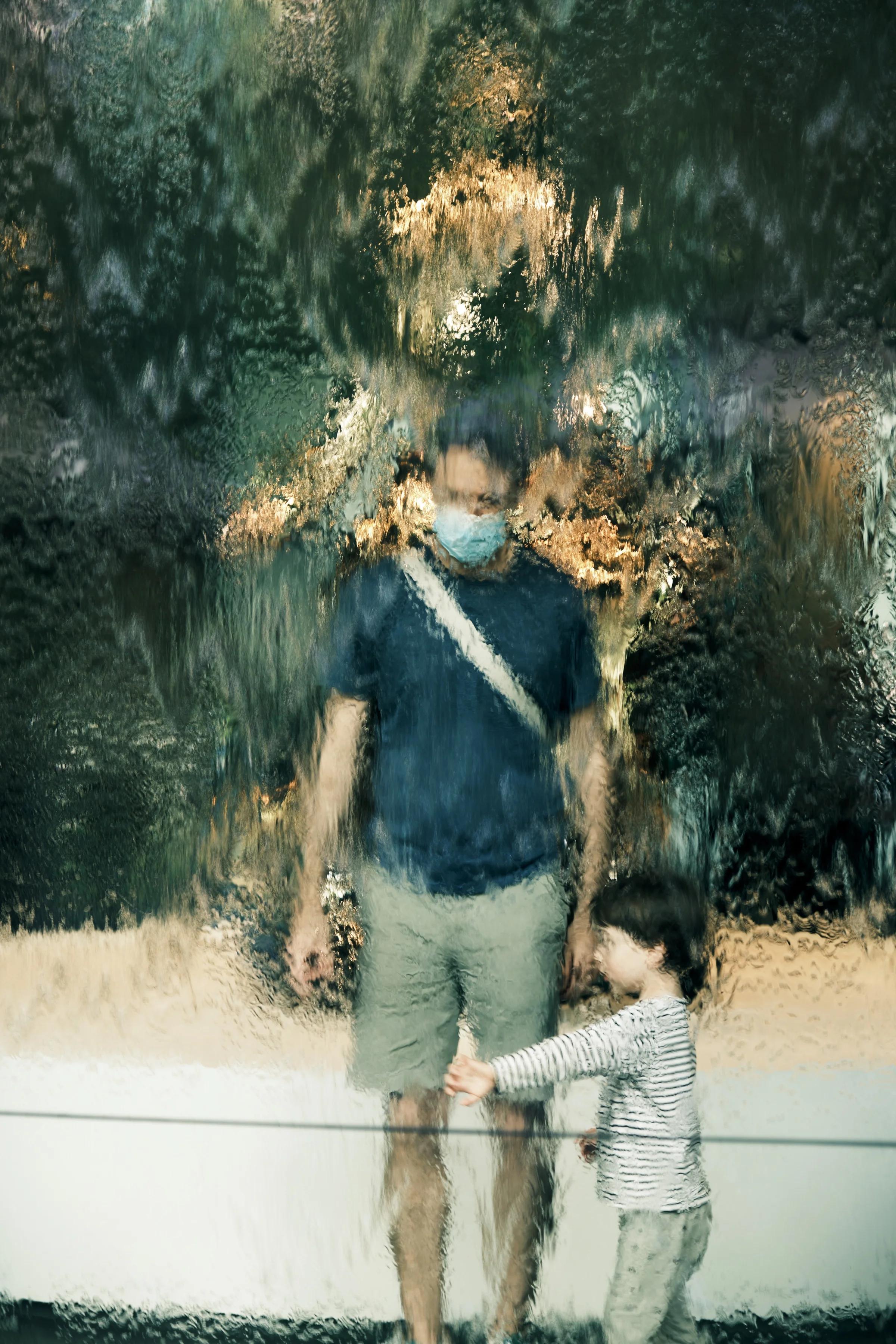 Father and Child Behind Waterfall Glass